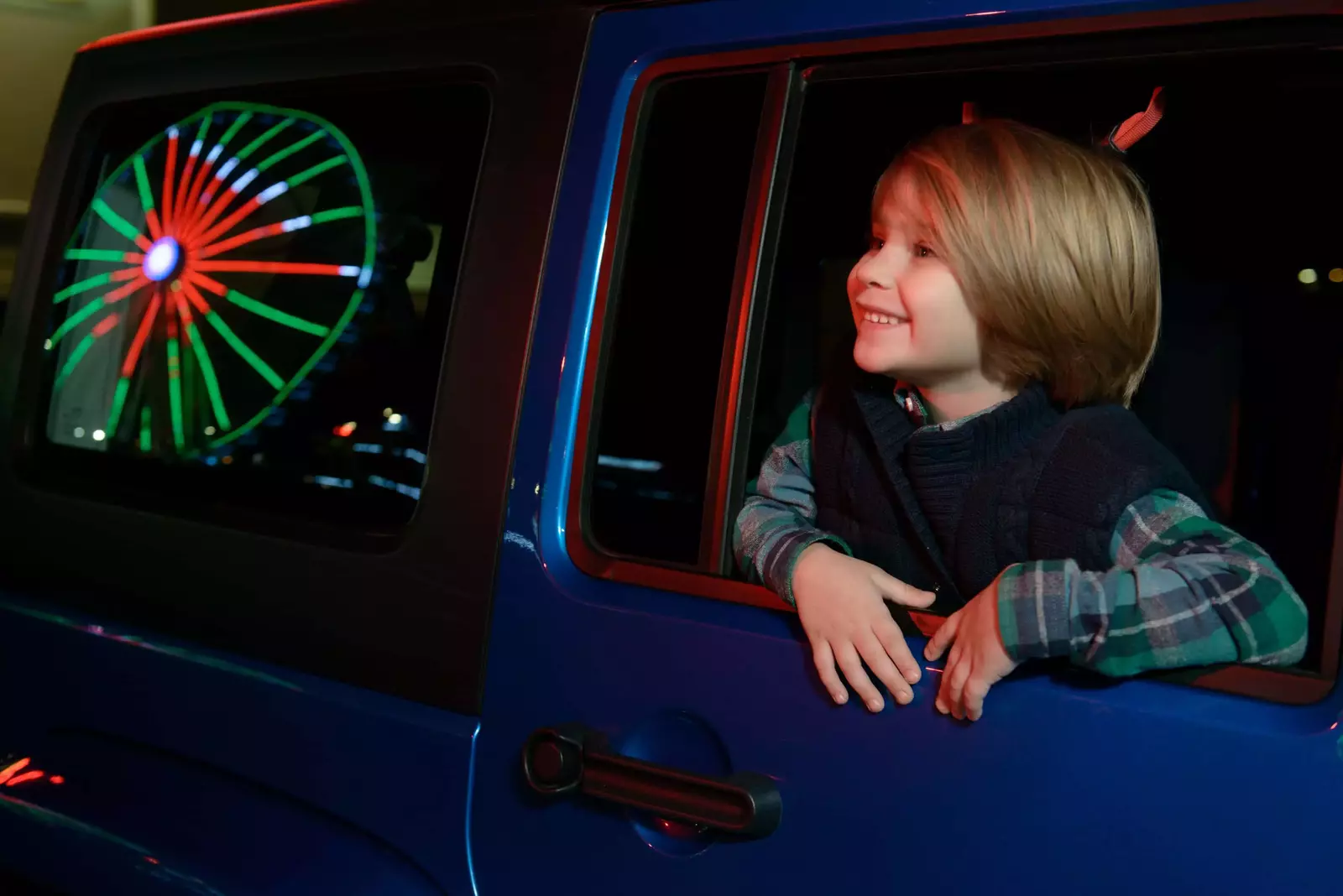 kid looking out the window of a jeep